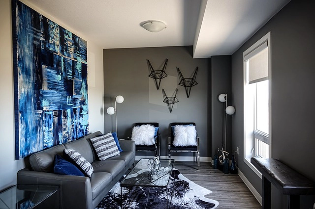 Living room with grey walls, leather sofa and large blue painting.