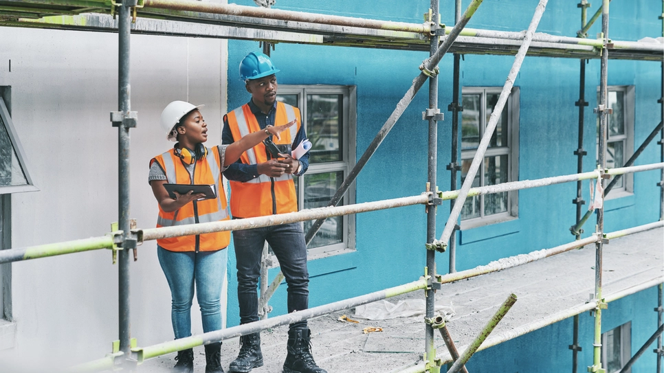 Two black South African construction workers on a construction site.