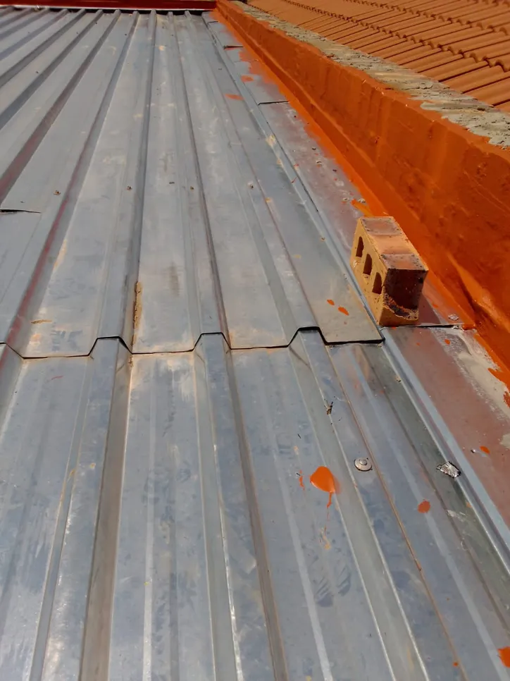 Corrugated metal roof showing signs of rust and potential water leakage issues.