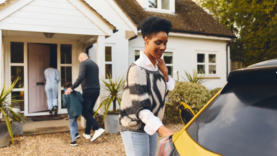 A family using a smart home ev charger with a yellow car.