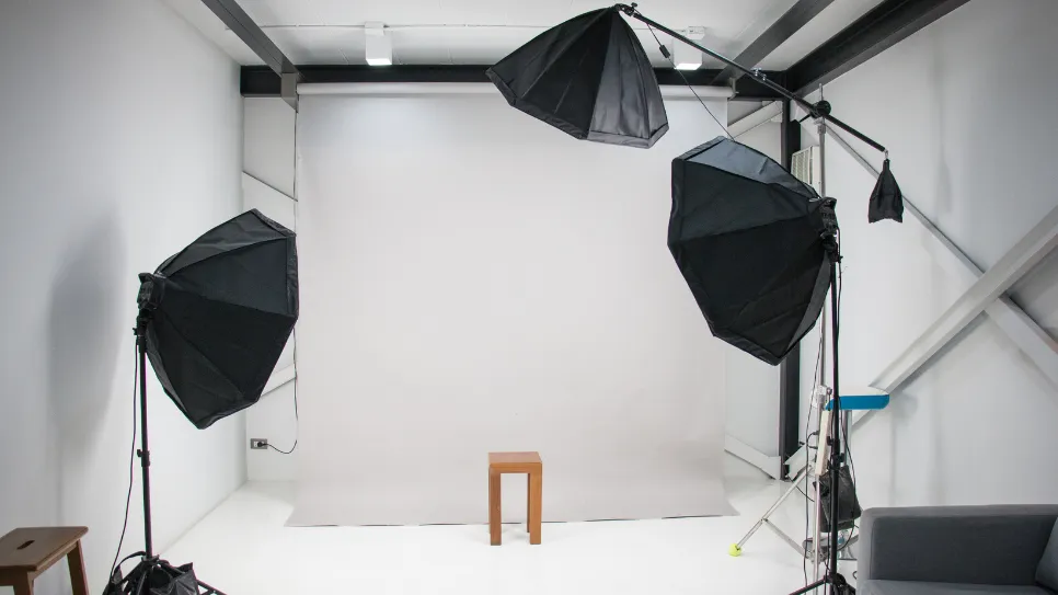 Minimalist photo studio setup featuring softbox lighting and a backdrop, prepared for professional photography sessions.
