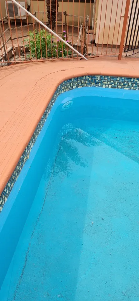 Swimming pool with visible dirt on the bottom, indicating water clarity issues.