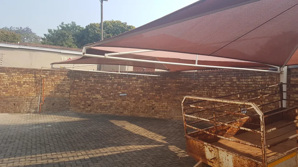 Large outdoor shade canopy installed over a brick patio with metal frame structure.