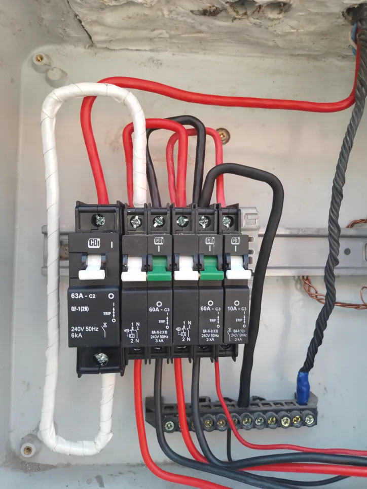 Circuit breaker panel with multiple wires connected, indicating electrical distribution setup.