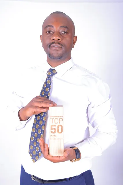 A professional lawyer from Nkuna & Associates Inc proudly displays the wooden Procompare.co.za TOP 50 award for 2025 against a clean white background, signifying their status as a premier South African service provider.