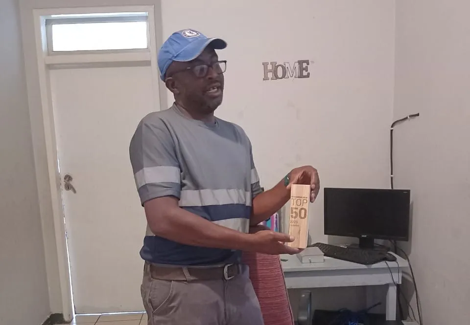 The owner of Insukamini proudly holding the Procompare.co.za TOP 50 2025 award, recognizing the business as one of the 50 most recommended service providers in the country.